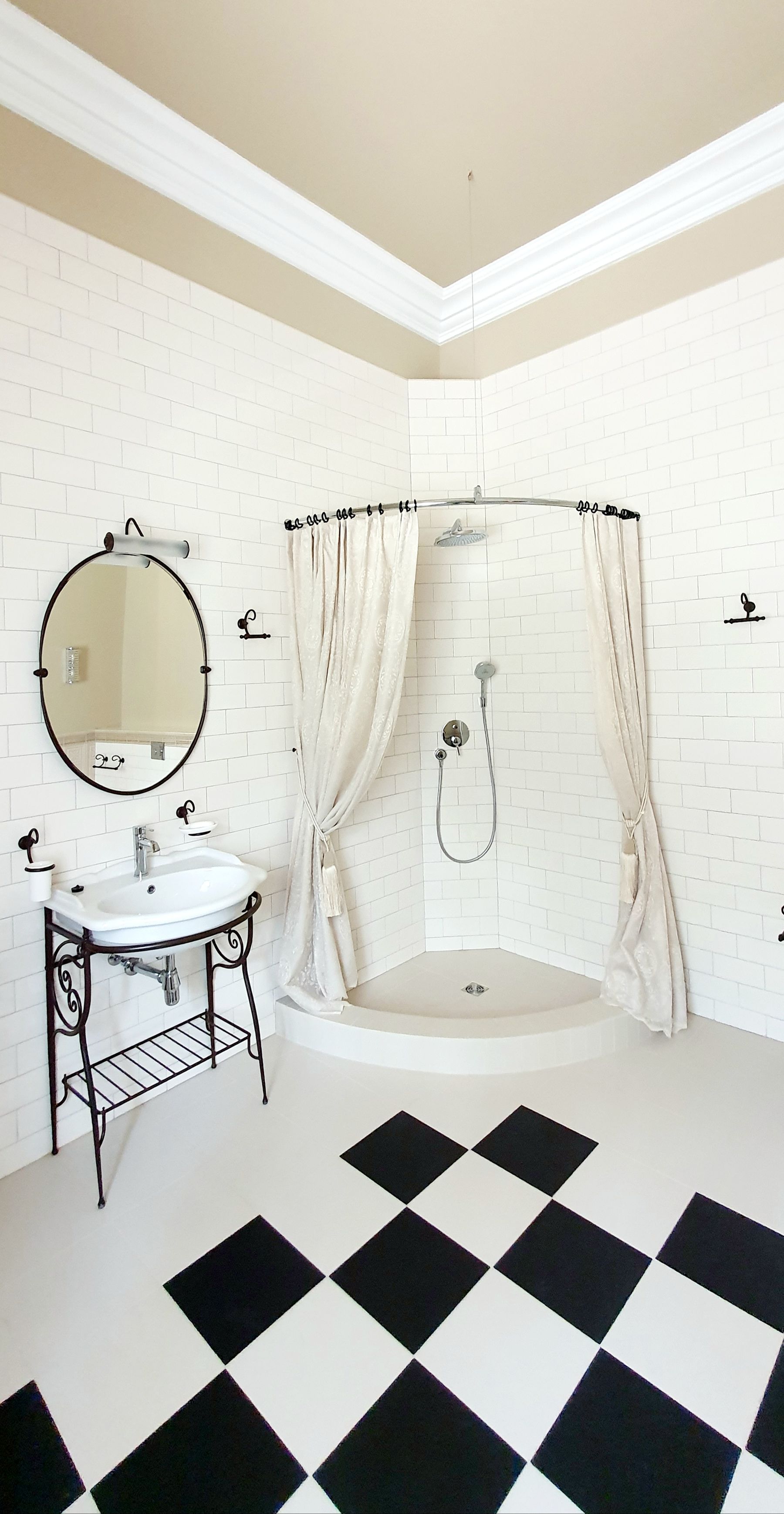 Bathroom with graphic checkerboard floor, pale walls and simple vintage-inspired fixtures