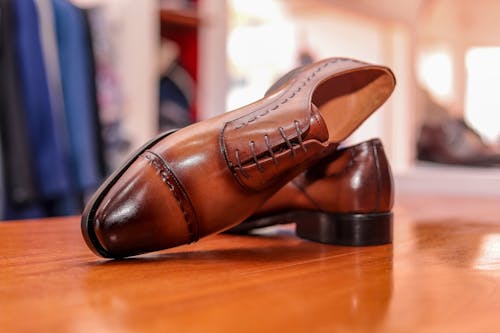 Brown Leather Shoe on Brown Wooden Table
