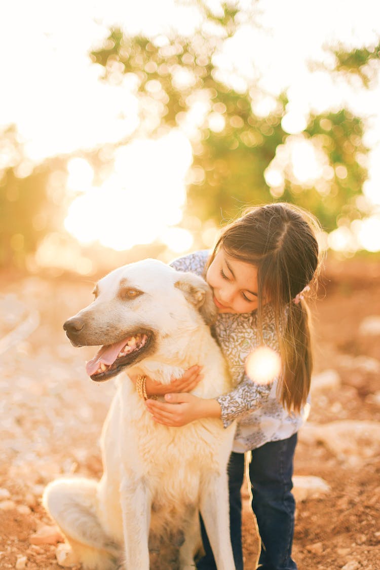 A Girl Hugging A Dog