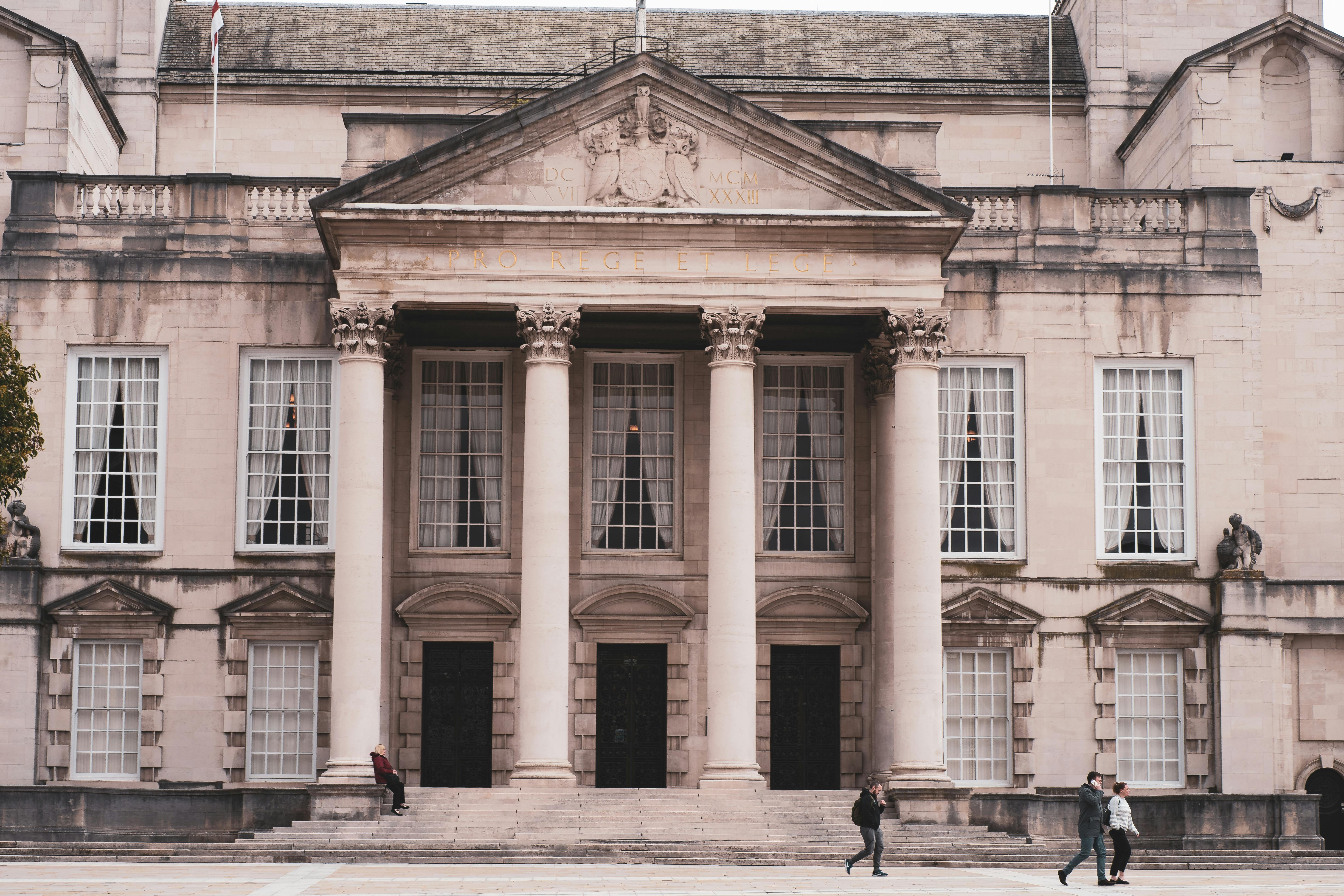 Classic architecture of a historic building in Leeds with people walking by.