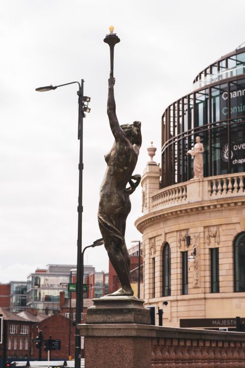 Free Bronze statue holding torch outside Leeds Civic Hall, England Stock Photo