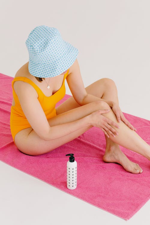 Free 
A Woman in a Bikini Applying Sunscreen on Her Skin Stock Photo