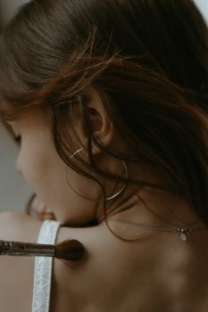 Elegant close-up portrait of a woman wearing a loop earring, highlighting her shoulder.