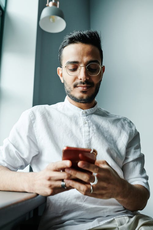 Bearded Man with Eyeglasses Using a Cellphone
