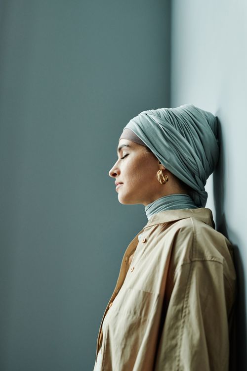 Free Profile of a serene woman in headscarf indoors with eyes closed, showcasing elegance and calm. Stock Photo