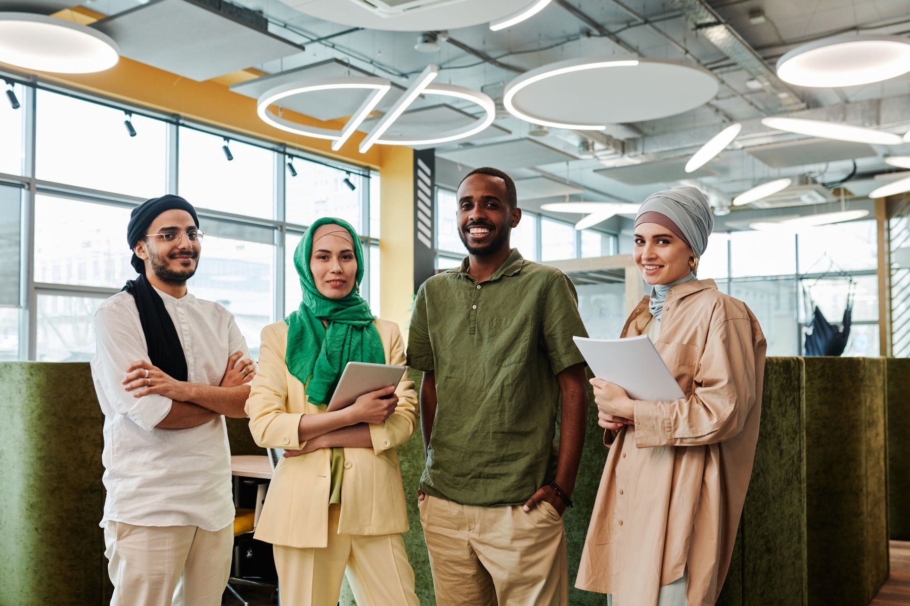 A visibly diverse group of professionals standing together in a modern workplace
