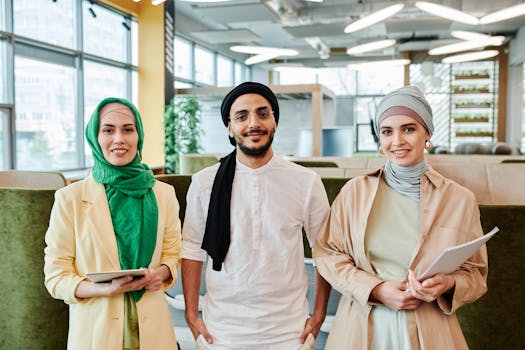A diverse professional team smiling and posing in a modern office setting.