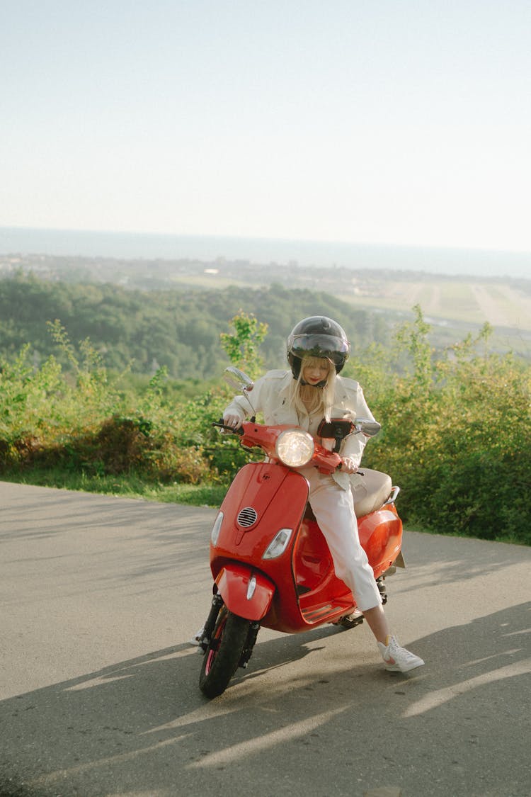 Woman Riding A Red Moped