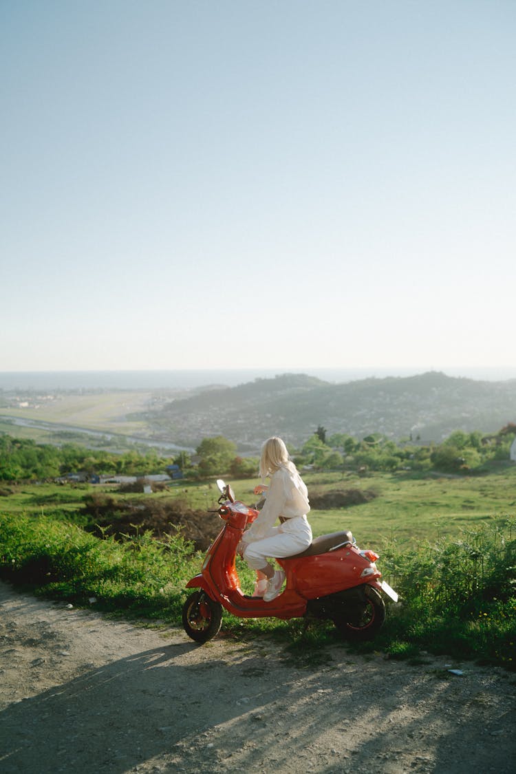 Woman Riding A Red Scooter