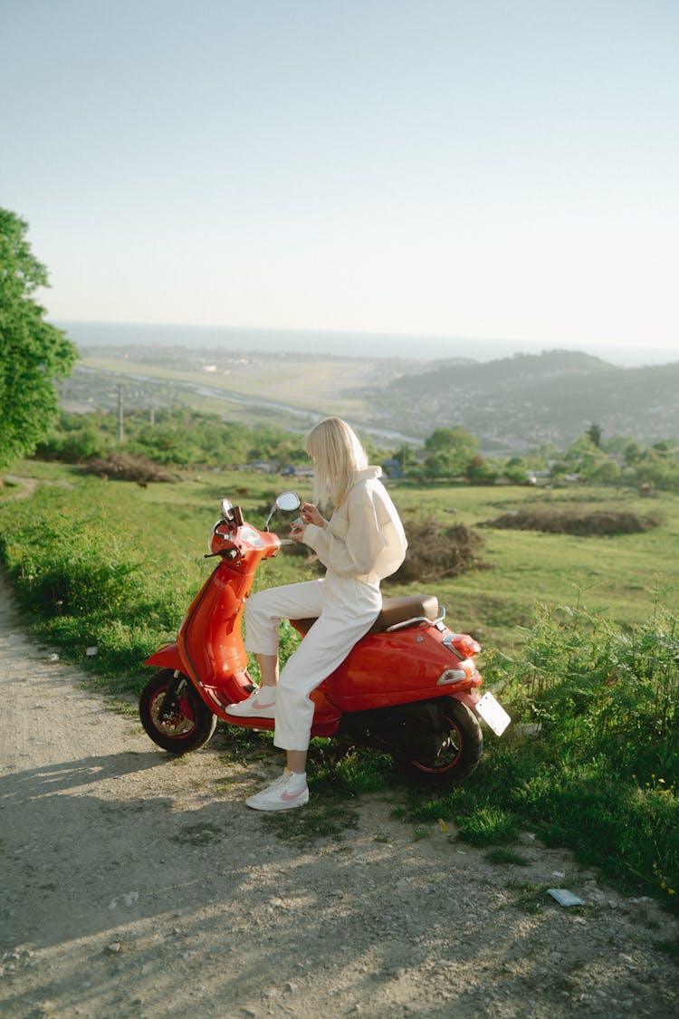 Woman Riding A Red Scooter