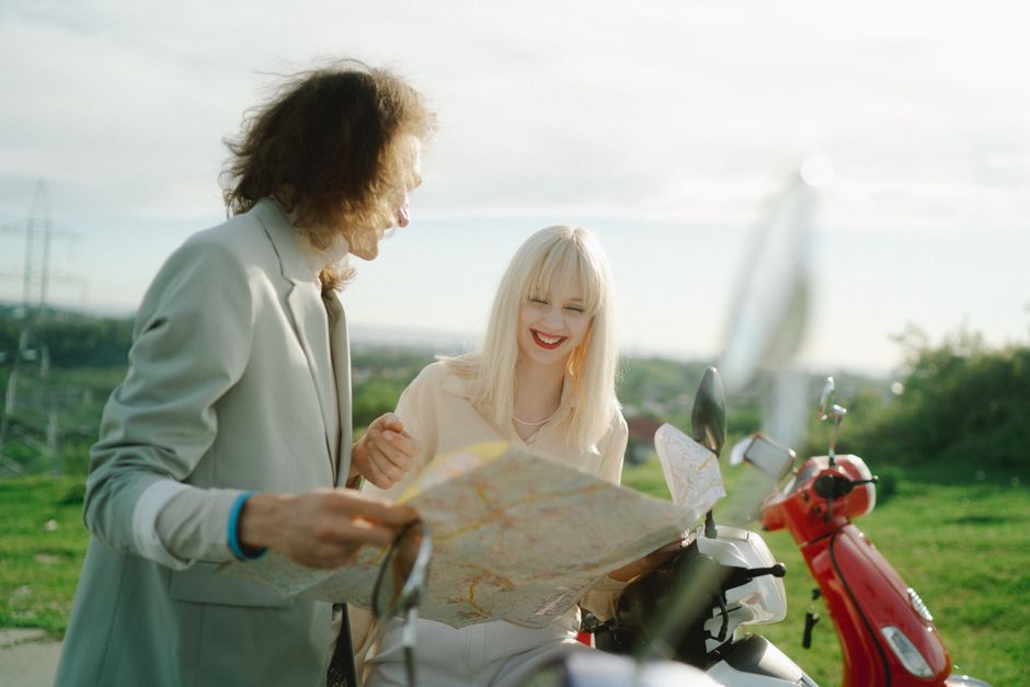 A Dutch couple happily planning their next trip on a map of the Netherlands