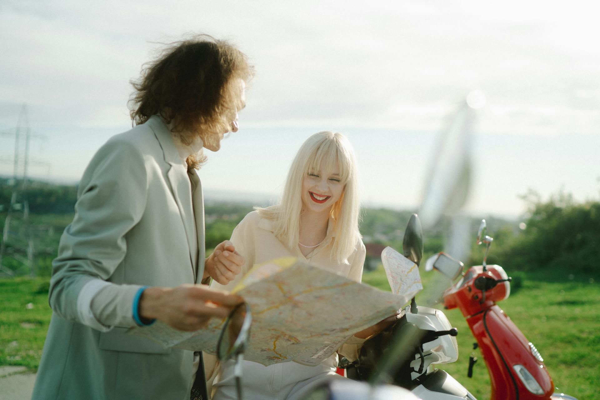 Happy couple exploring with a map on a sunny day, planning their journey with excitement.