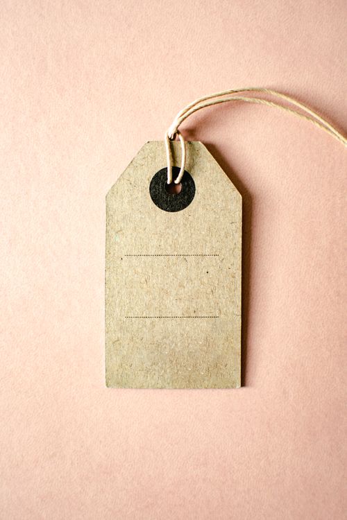 Free A simple brown paper tag with twine on a pink surface, ideal for product branding. Stock Photo