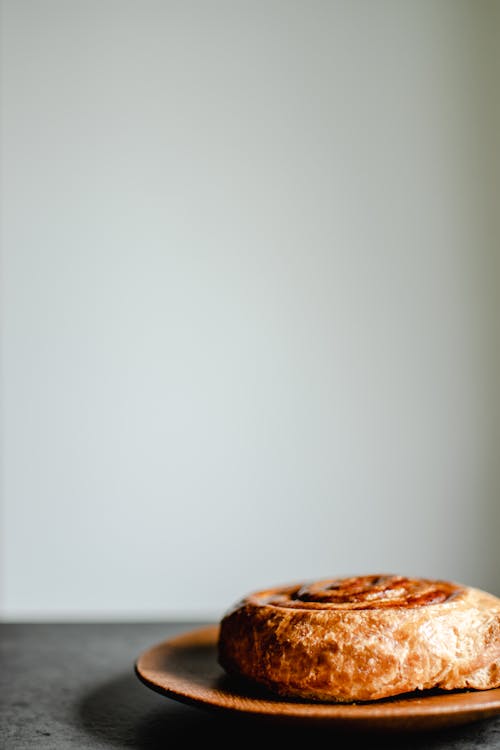 Free Cinnamon Roll on Brown Plate Stock Photo