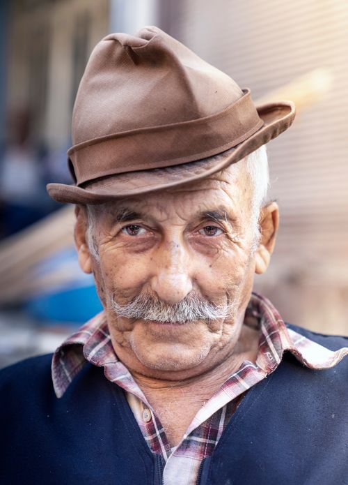 Free Portrait of an elderly man with a hat and mustache, exuding character and warmth. Stock Photo