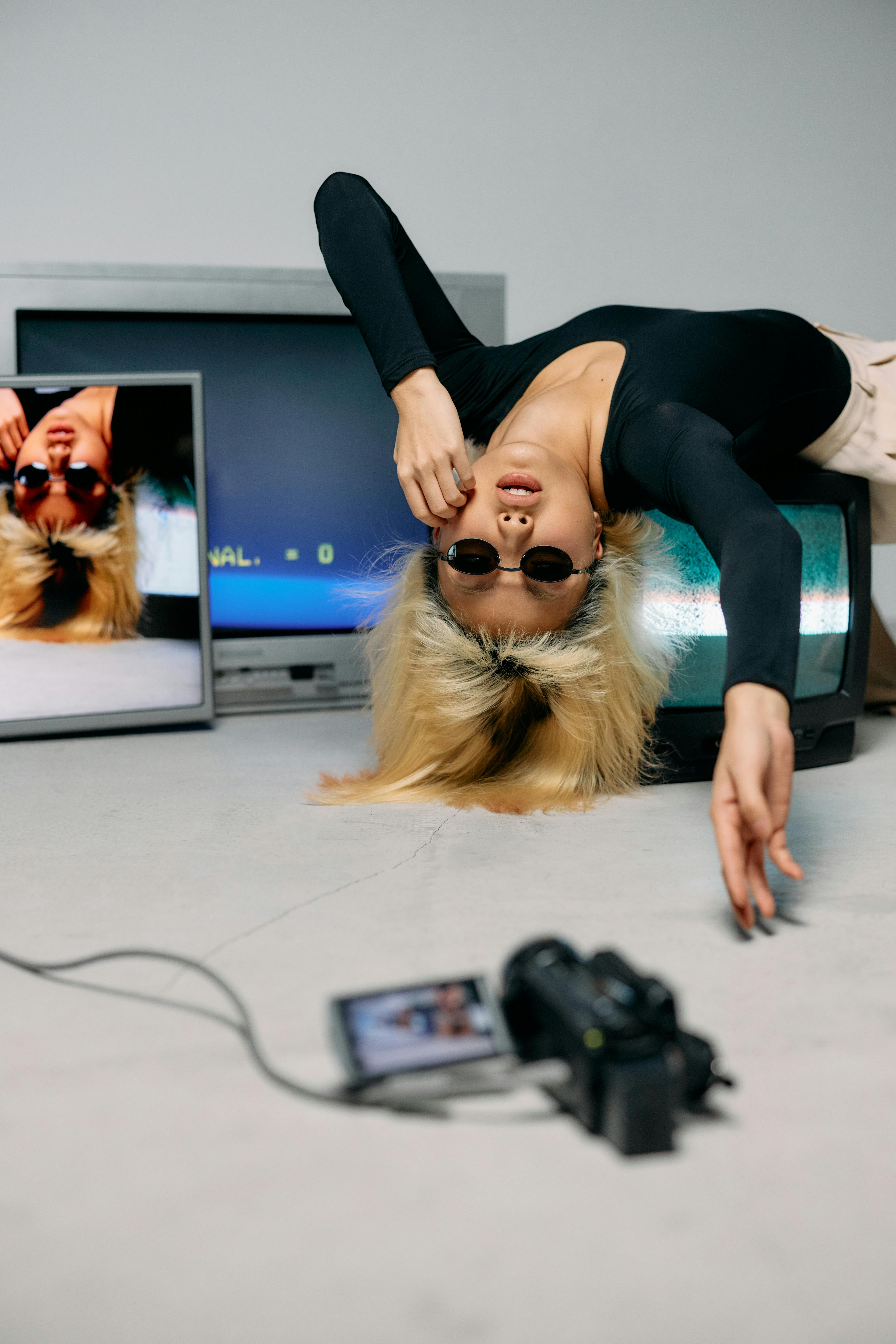 photo of woman laying on top of monitor