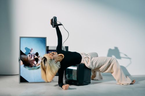 Free Stylish woman posing with vintage CRTs in a modern editorial photoshoot. Stock Photo