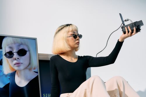 Free Chic editorial shot featuring a stylish model with vintage electronics, embracing a trendy and conceptual look. Stock Photo