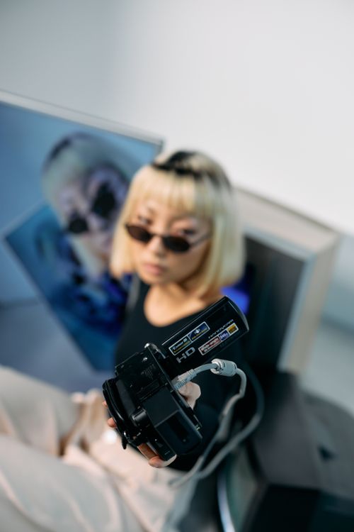 Free Fashionable model with blond hair posing with vintage electronics in a studio setting. Stock Photo