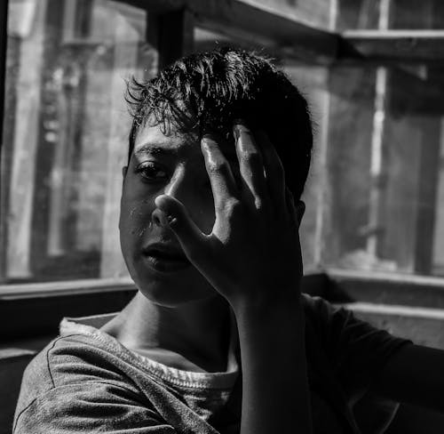 Grayscale Photo of a Boy in Anguish