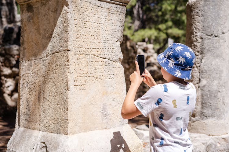 Boy Taking Photo Of Old Monument