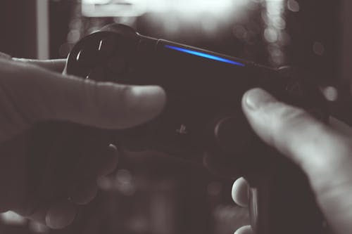 Black And White Photo Of Man Holding Sony Ps4 Wireless Controller