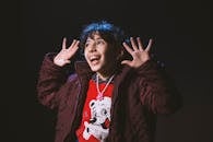 孩子穿着冬季夹克，戴着项链，笑容满面地表达喜悦