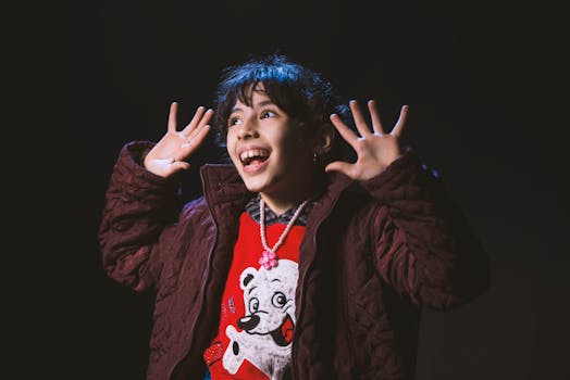 孩子穿着冬季夹克，戴着项链，笑容满面地表达喜悦