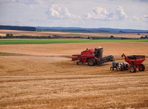 Farmers using Tractors on a Farm Field