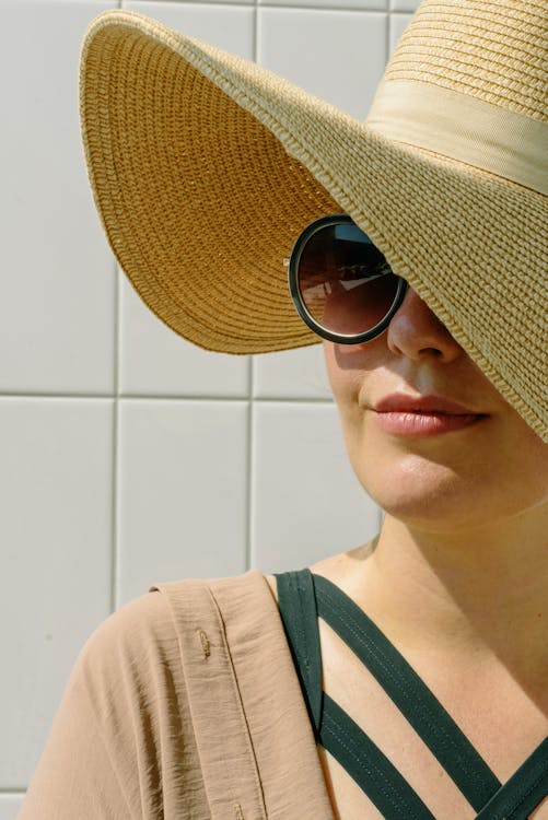 Free A Close-Up Shot of a Woman Wearing Sunglasses and a Hat Stock Photo