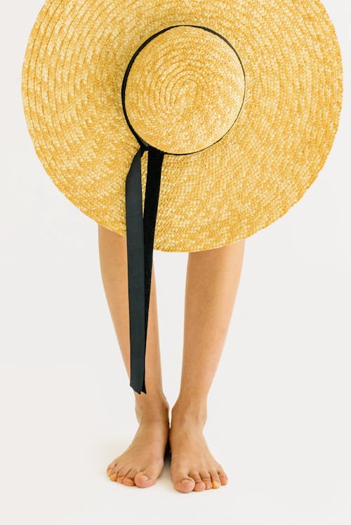 
A Close-Up Shot of a Hat and a Person's Feet