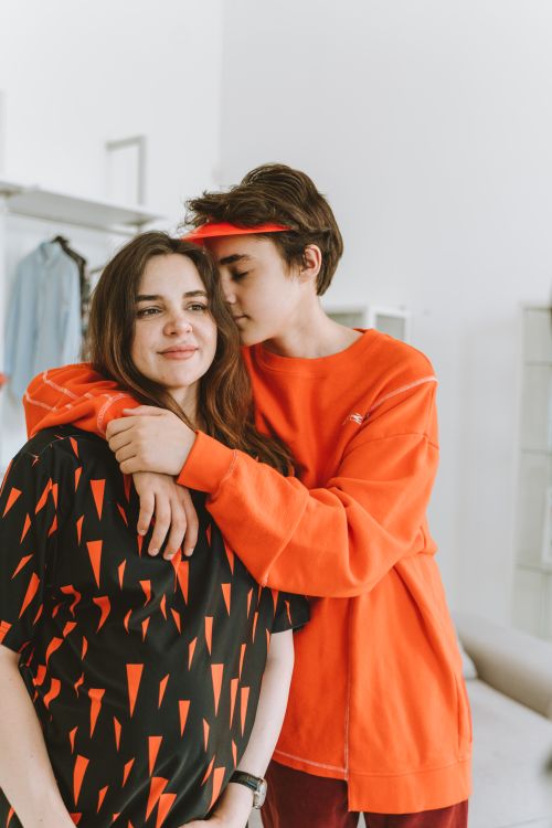 Free A touching moment of a teenage boy hugging his mother in a cozy indoor setting. Stock Photo
