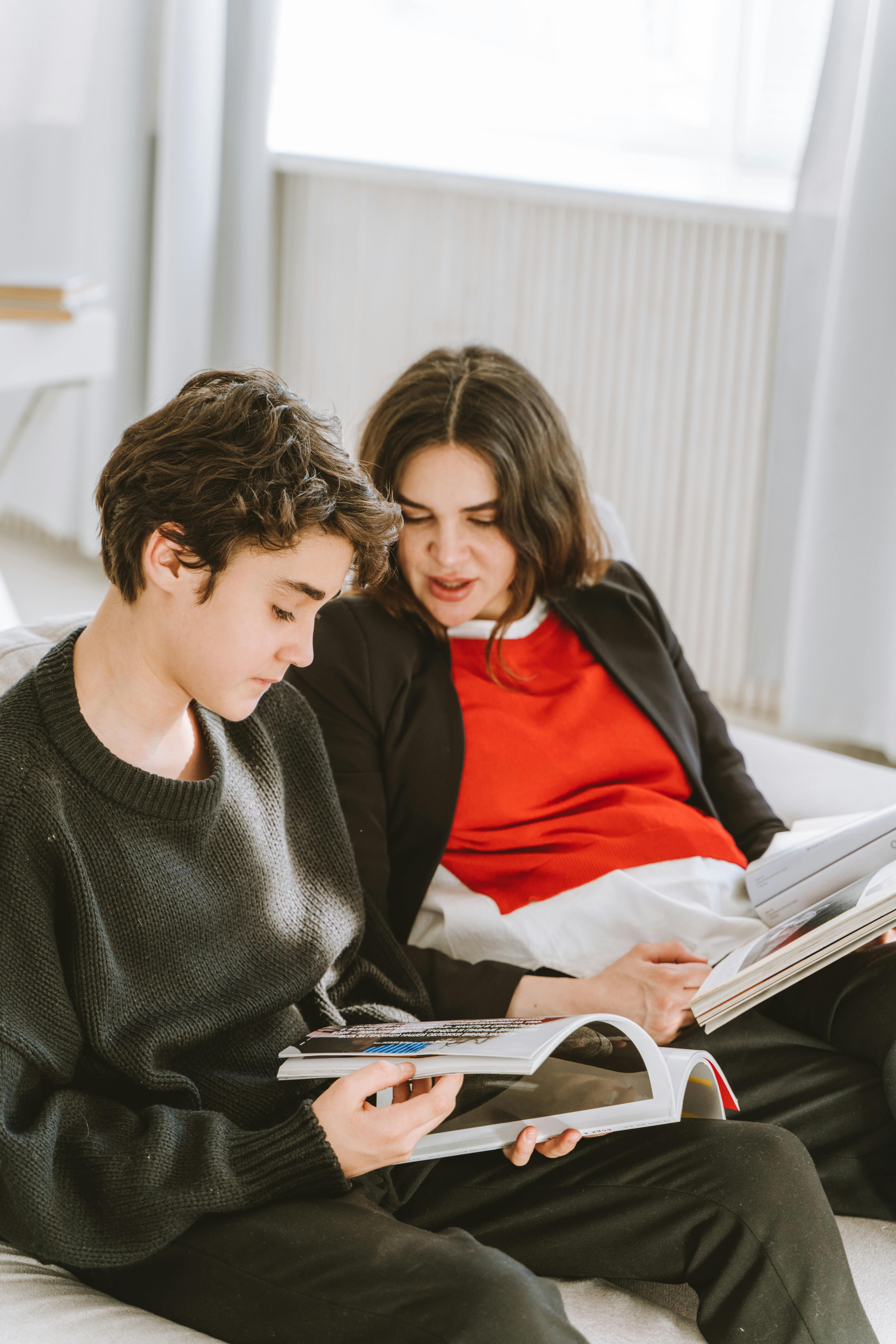 a woman talking to her son while looking at the magazine