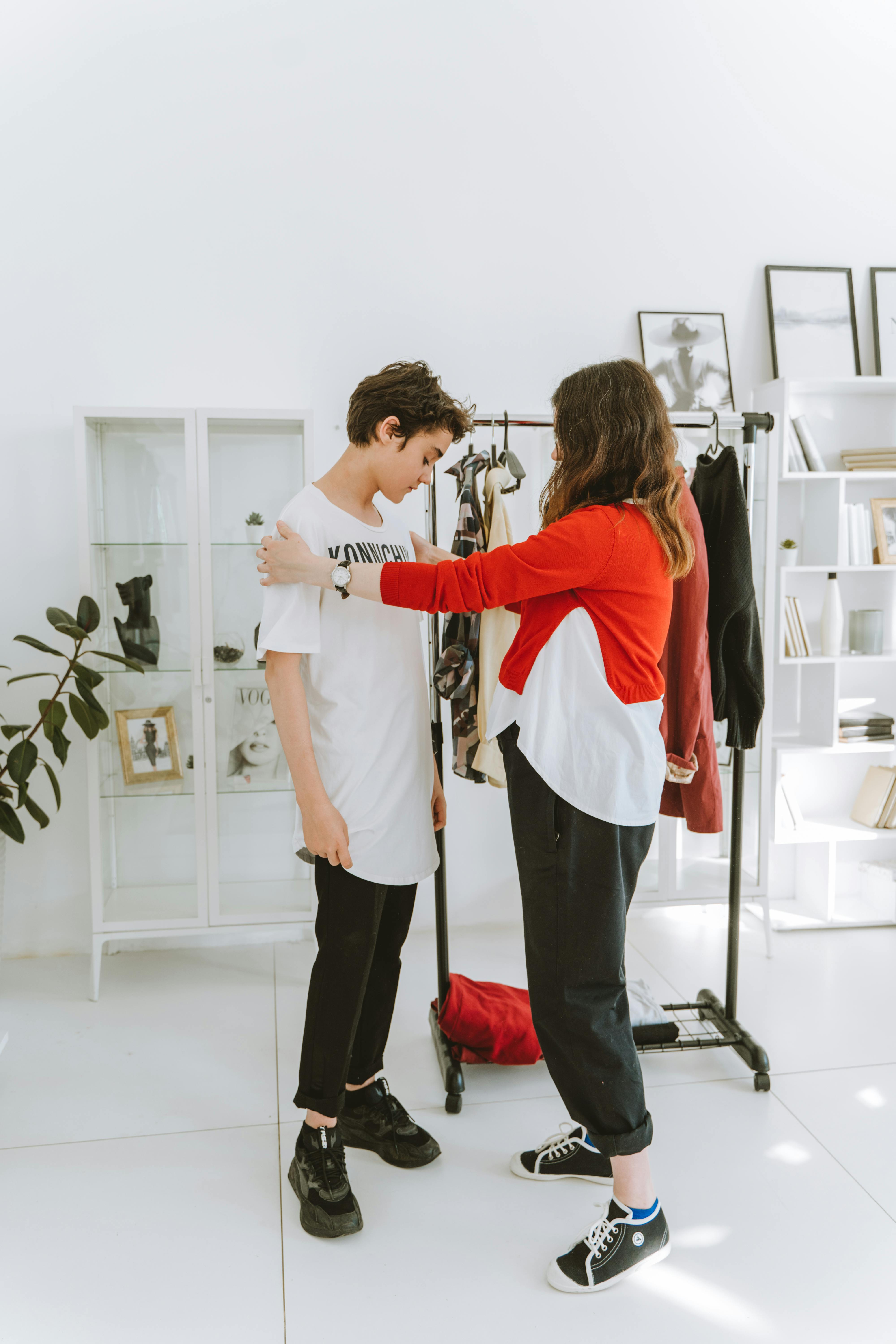 a woman looking at her son in white shirt standing