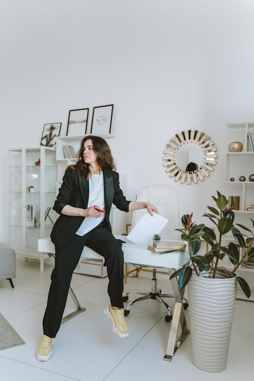 Free A Woman in Black Blazer Sitting on the Table Stock Photo