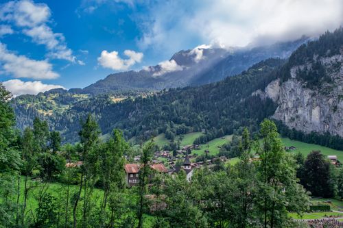 Free Discover a picturesque alpine village nestled among majestic mountains and lush forests. Stock Photo
