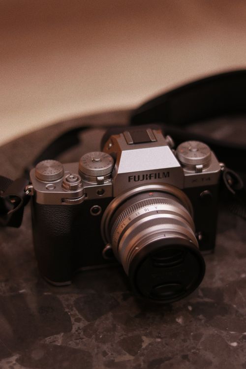 Free Close-up of a vintage Fujifilm camera placed on a marble surface, capturing retro elegance. Stock Photo