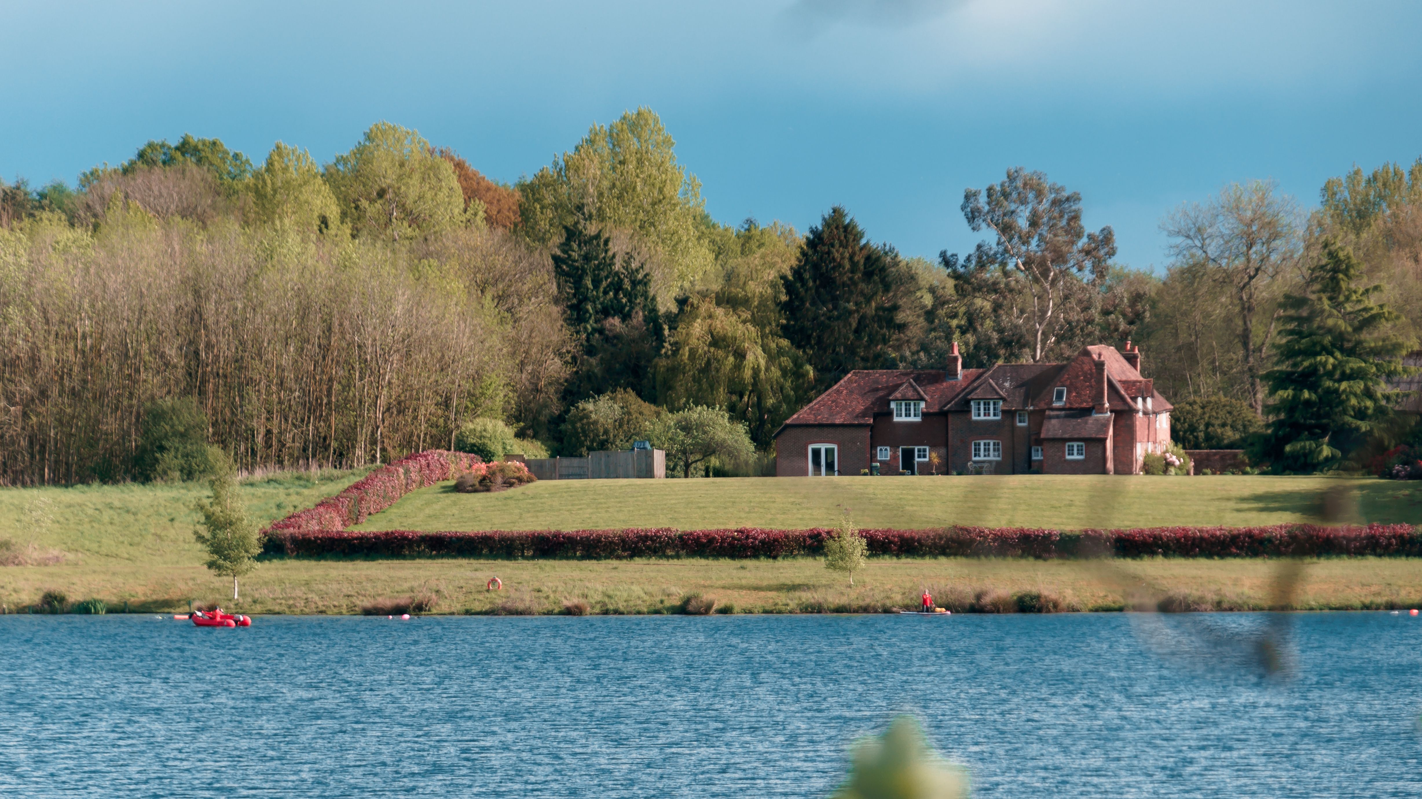 Brown House Near Green Trees and Lake · Free Stock Photo