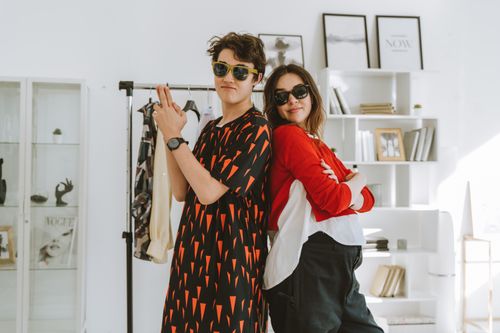 Free Stylish young models posing back-to-back indoors, embracing modern fashion trends. Stock Photo