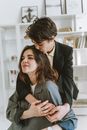 Man in Black Suit Jacket Hugging Woman in Gray Blazer