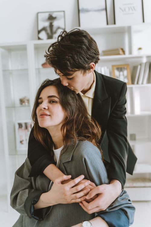 Free A warm embrace between a mother and her teenage son in a modern home setting, conveying love and affection. Stock Photo