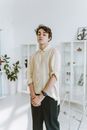 Woman in Beige Button Up Shirt and Black Pants Sitting on White Ceramic Bathtub