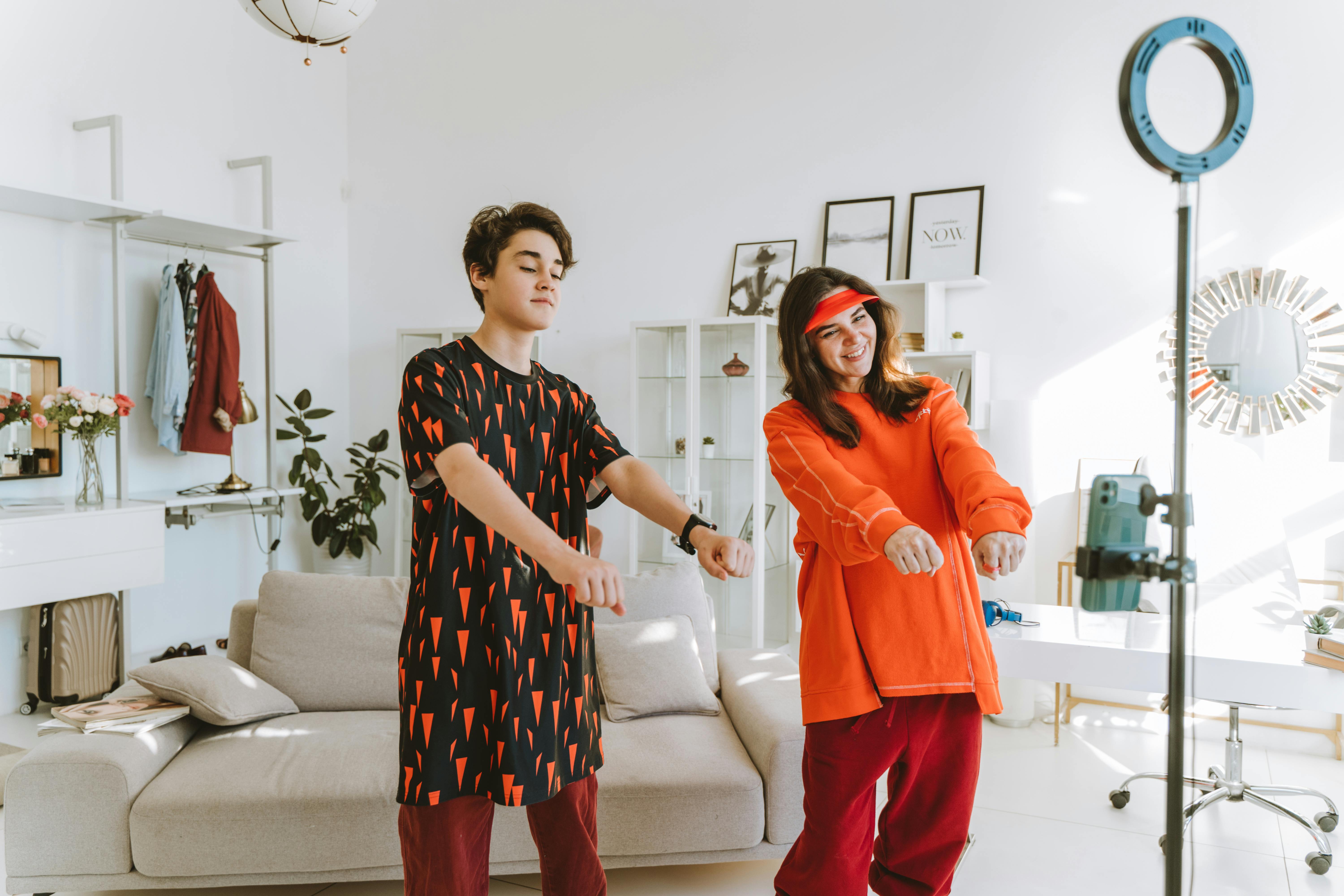 Mother and son enjoy a dance session in a trendy and cozy living room, capturing a fun family moment.