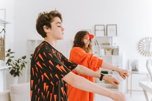 Free Teens enjoy dancing indoors in vibrant outfits, capturing a fun and lively moment. Stock Photo