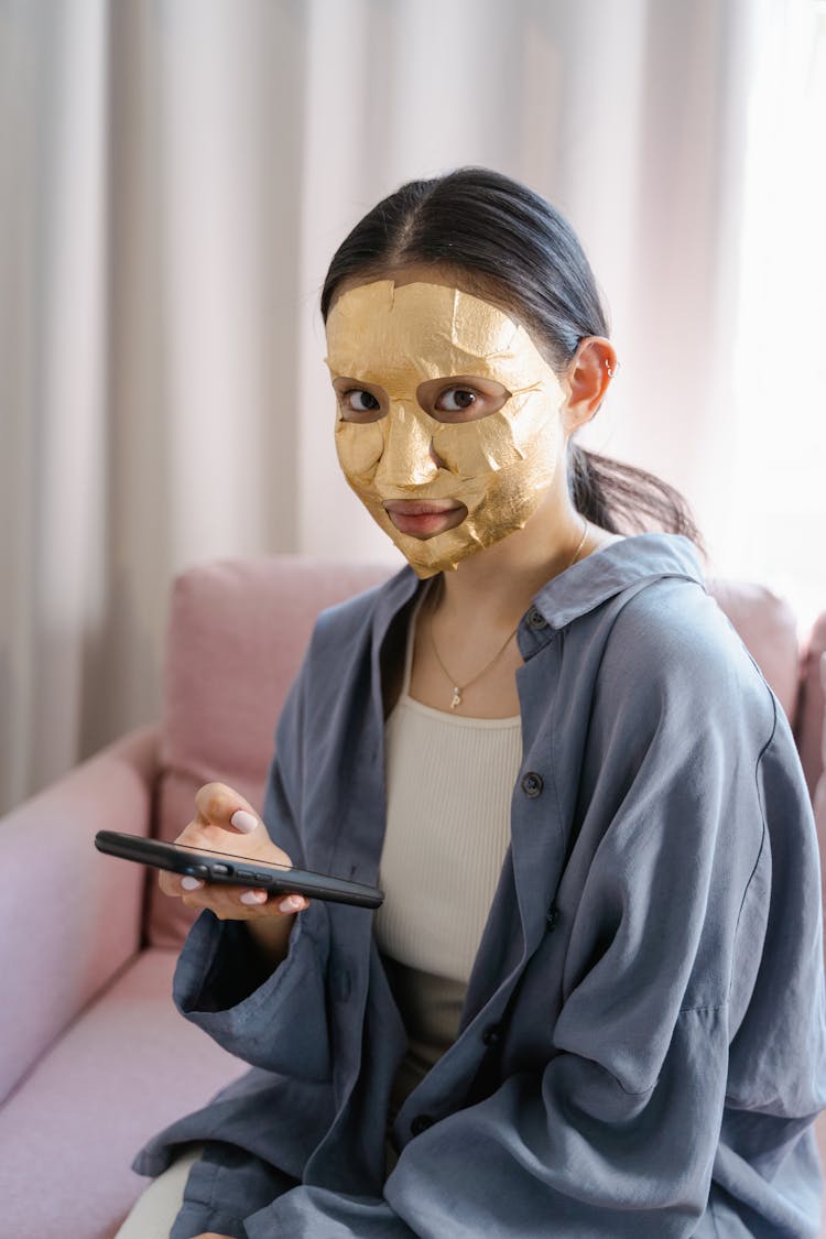 Woman Applied Gold Sheet Face Mask On Her Face 