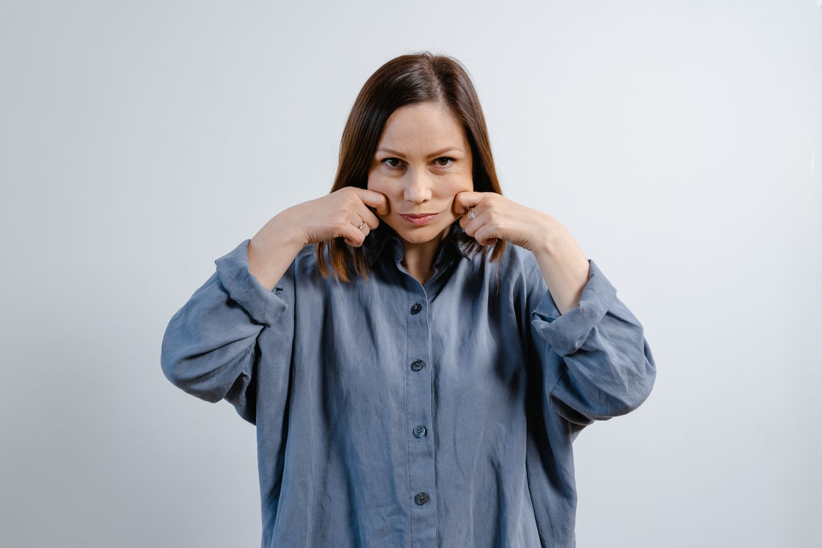 Woman demonstrating a face yoga exercise for facial muscle toning