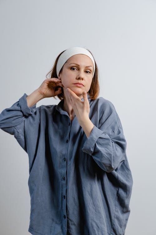 Woman in Button Sown Shirt Holding Her Face