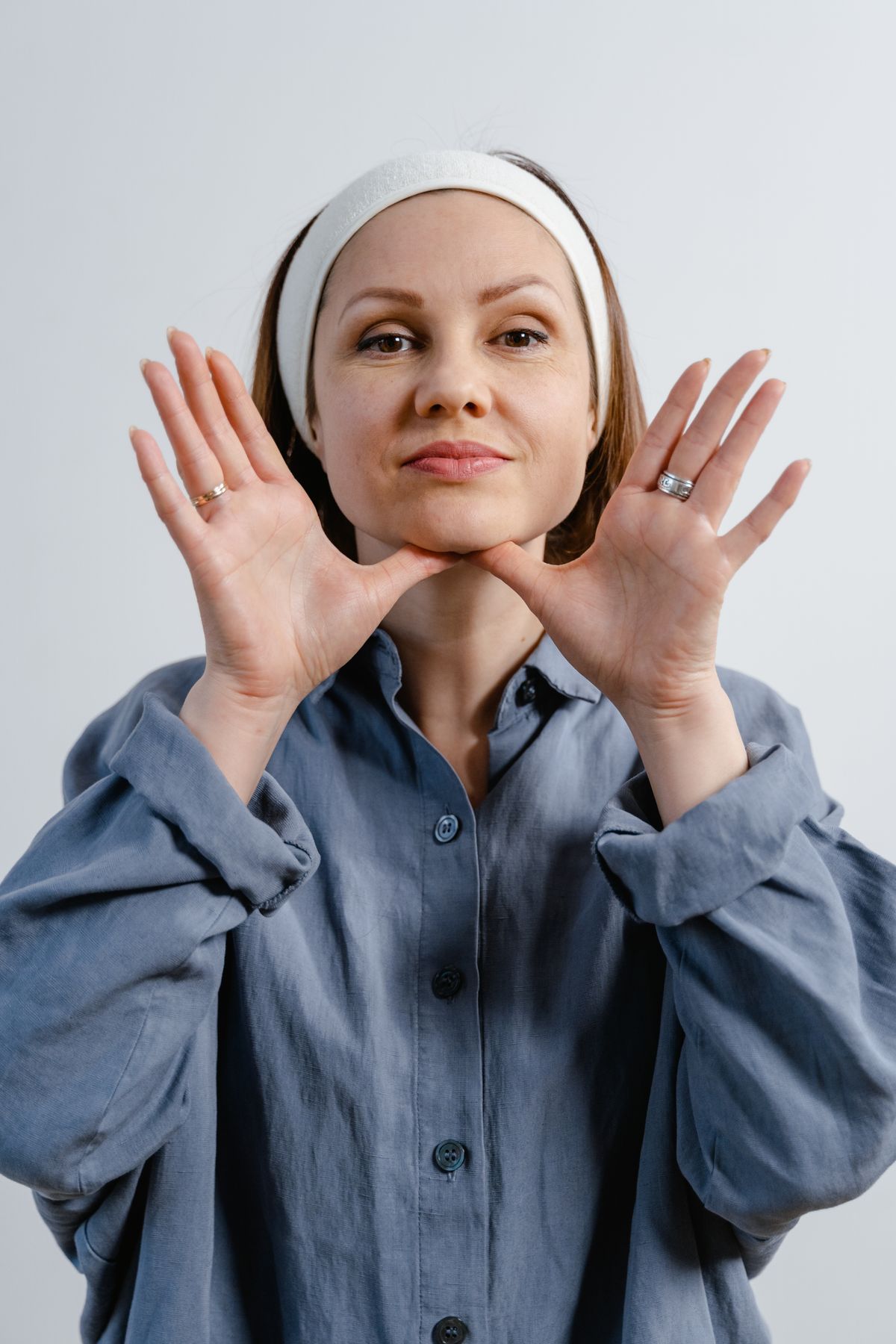Woman performing facial massage with hands on chin