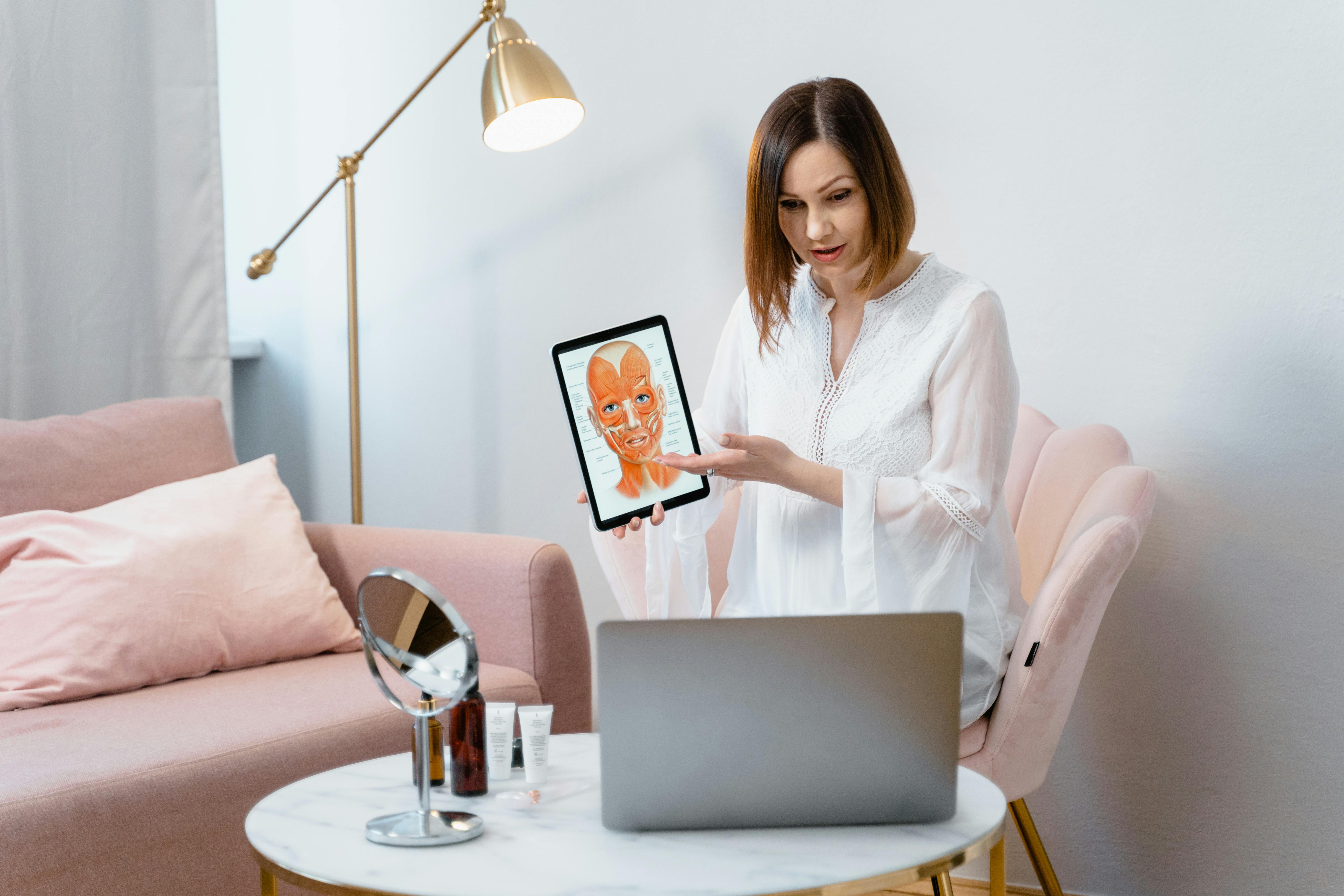 woman showing a picture of the anatomy of face muscles