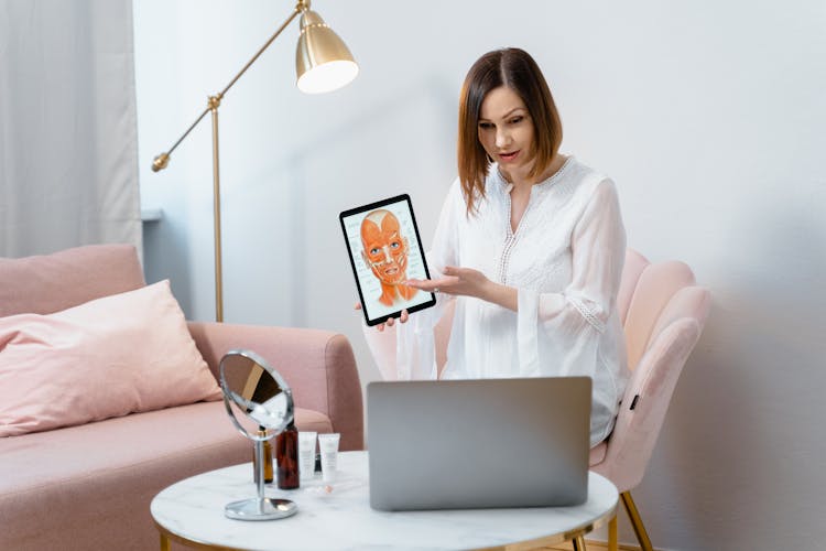 Woman Showing A Picture Of The Anatomy Of Face Muscles